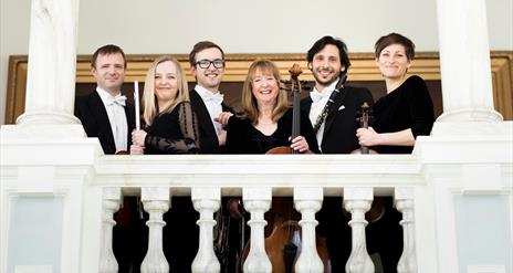 Ulster Orchestra members gathered on a white stone balcony