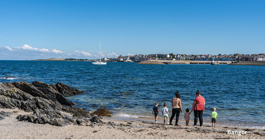 Adults and Children enjoying views from the beach over Bangor Bay