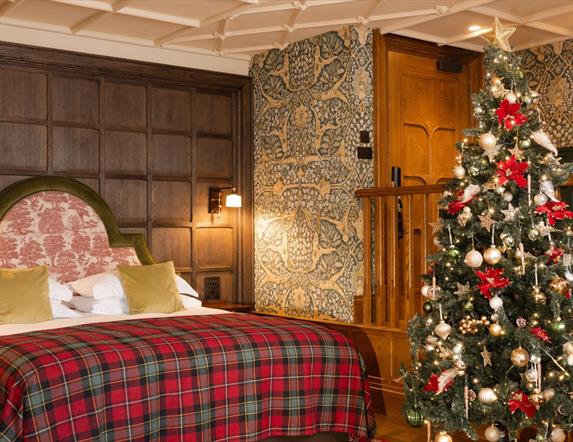 Junior suite with a large bed with checkered bedding and a christmas tree