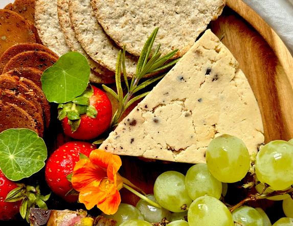 A selection of cheese, crackers, fruit and garnish
