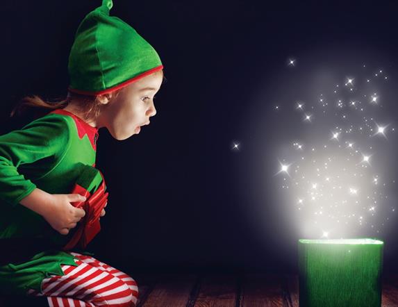 Child dressed as an elf opening a magical present.