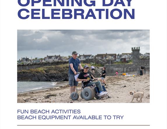 Image showing a young adult on Groomsport Beach seated in an all-terrain beach wheelchair. He is accompanied by a male friend pushing the chair and is