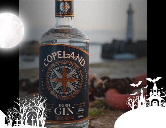 A bottle of Copeland Gin with Donaghadee Lighthouse in the background, with an overlay of spooky themed graphics for Hallowe'en
