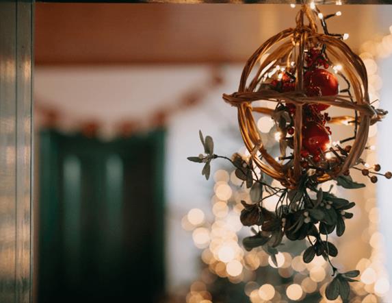 Focus on Christmas hanging decor with twinkling lights in the background