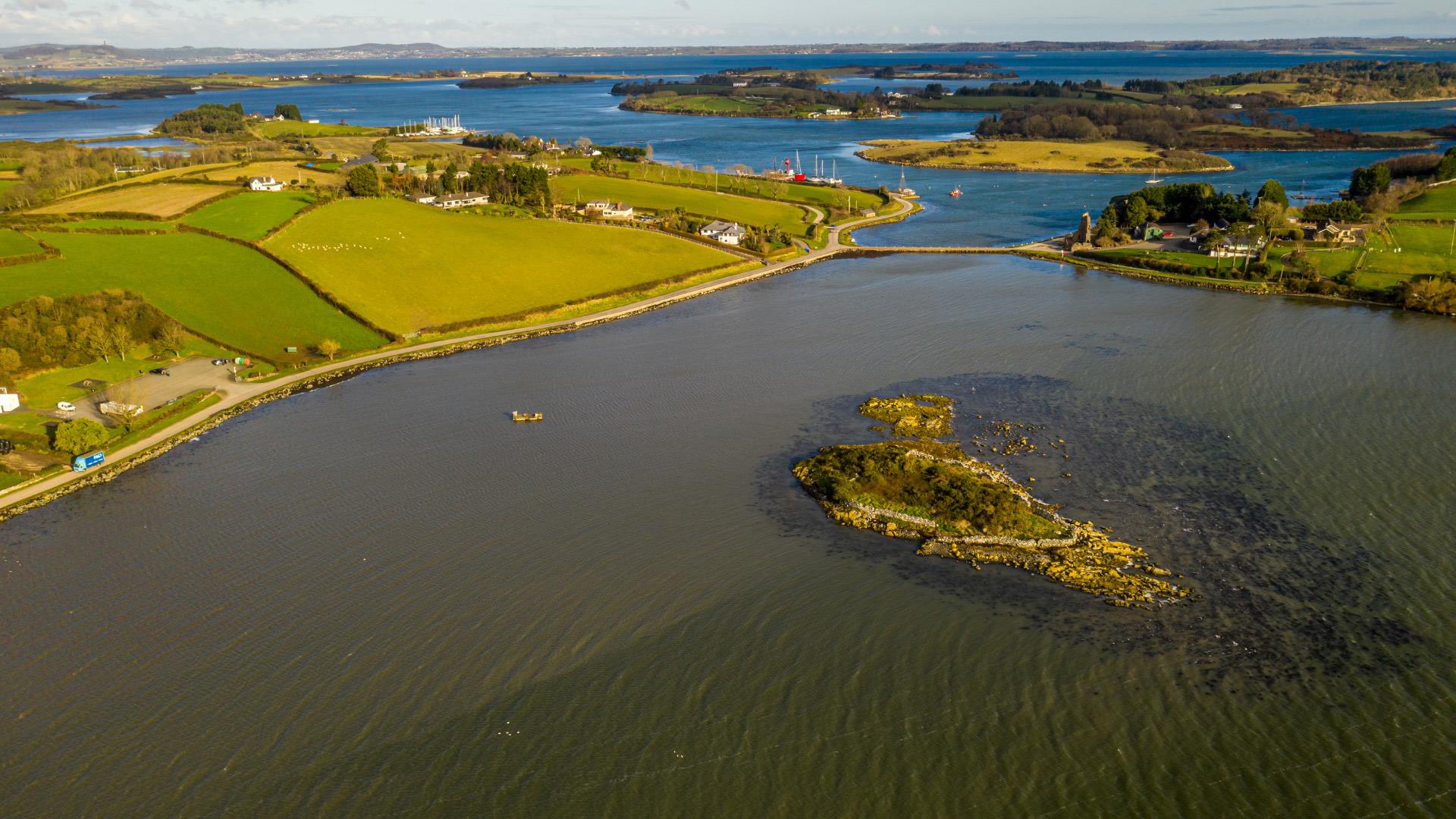 Strangford Lough near Newtownards, Northern Ireland, showing calm waters with boats and distant hills under a soft sky, reflecting the peaceful atmosphere.
