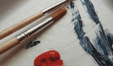 Paintbrushes and paint on paper