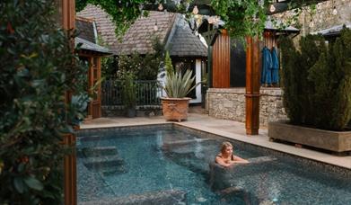 Blonde female in outdoor hot pool 