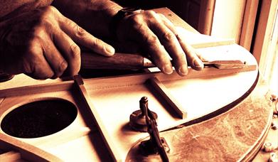 A luthier working on a guitar