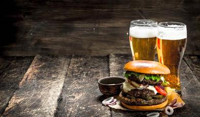 An image of two pints and a burger