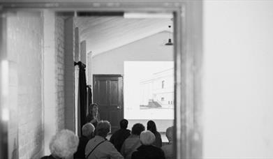 A black and white image of a woman giving a lecture