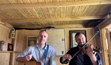 Two men holding instruments