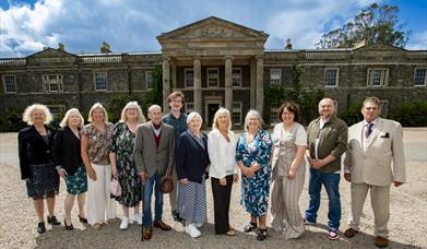 A group of people standing in front of Mount Stewart House  