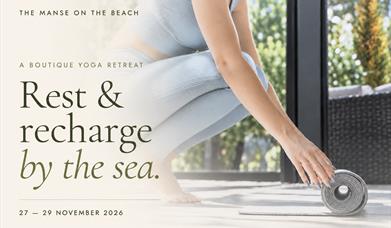 Woman rolling out a yoga mat. The Manse on the Beach boutique yoga retreat, 27–29 November 2026. Rest & recharge by the sea.