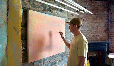 Ross Miley painting on a canvas