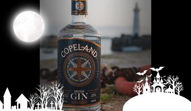 A bottle of Copeland Gin with Donaghadee Lighthouse in the background, with an overlay of spooky themed graphics for Hallowe'en