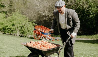 a man pushing a cart of eggs for an easter egg hunt