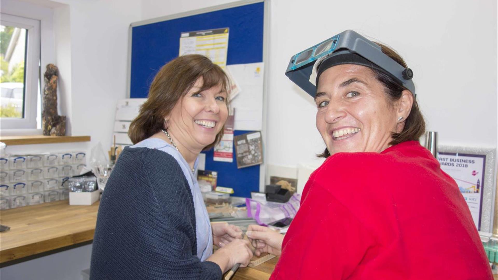 Two happy silver jewellery making women looking towards the camera smiling
