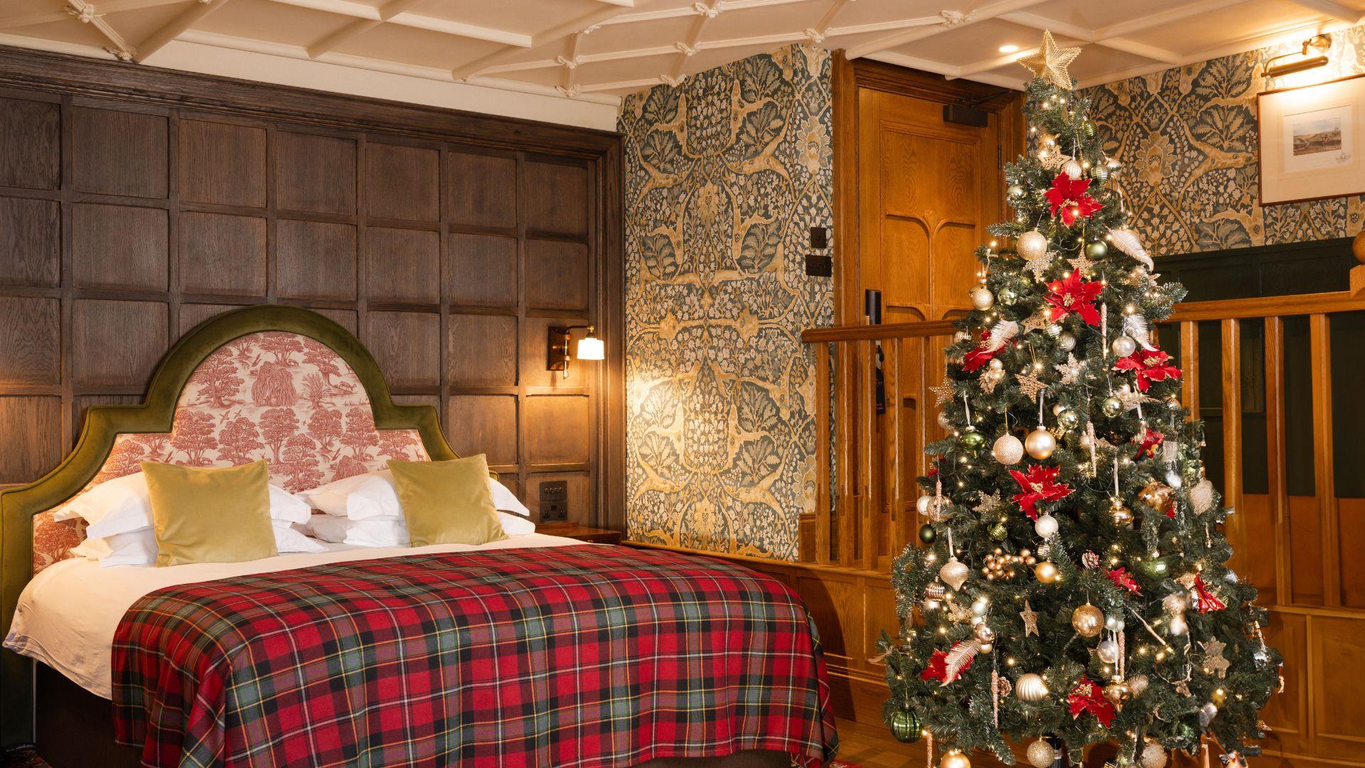 Junior suite with a large bed with checkered bedding and a christmas tree