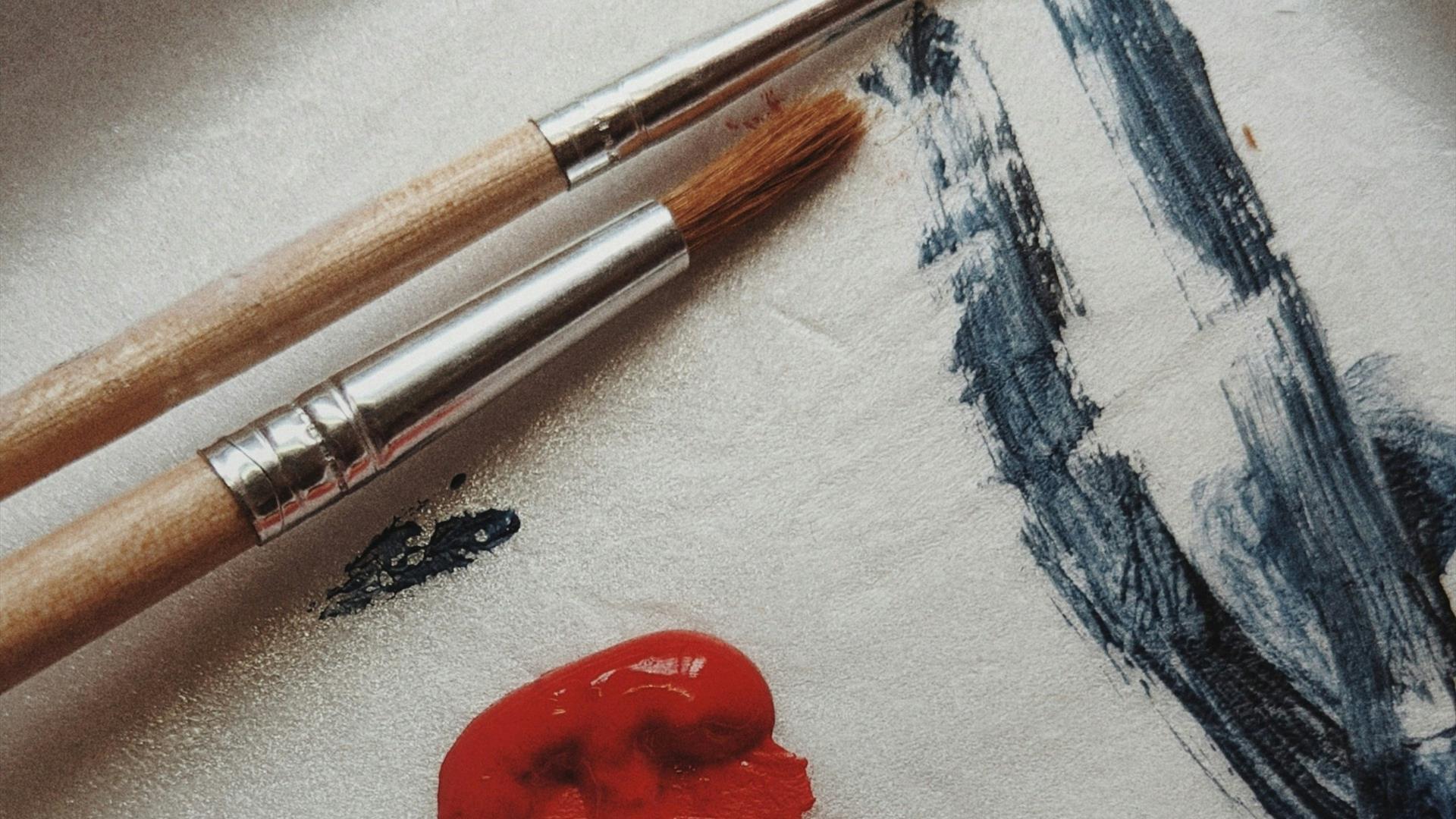 Paintbrushes and paint on paper