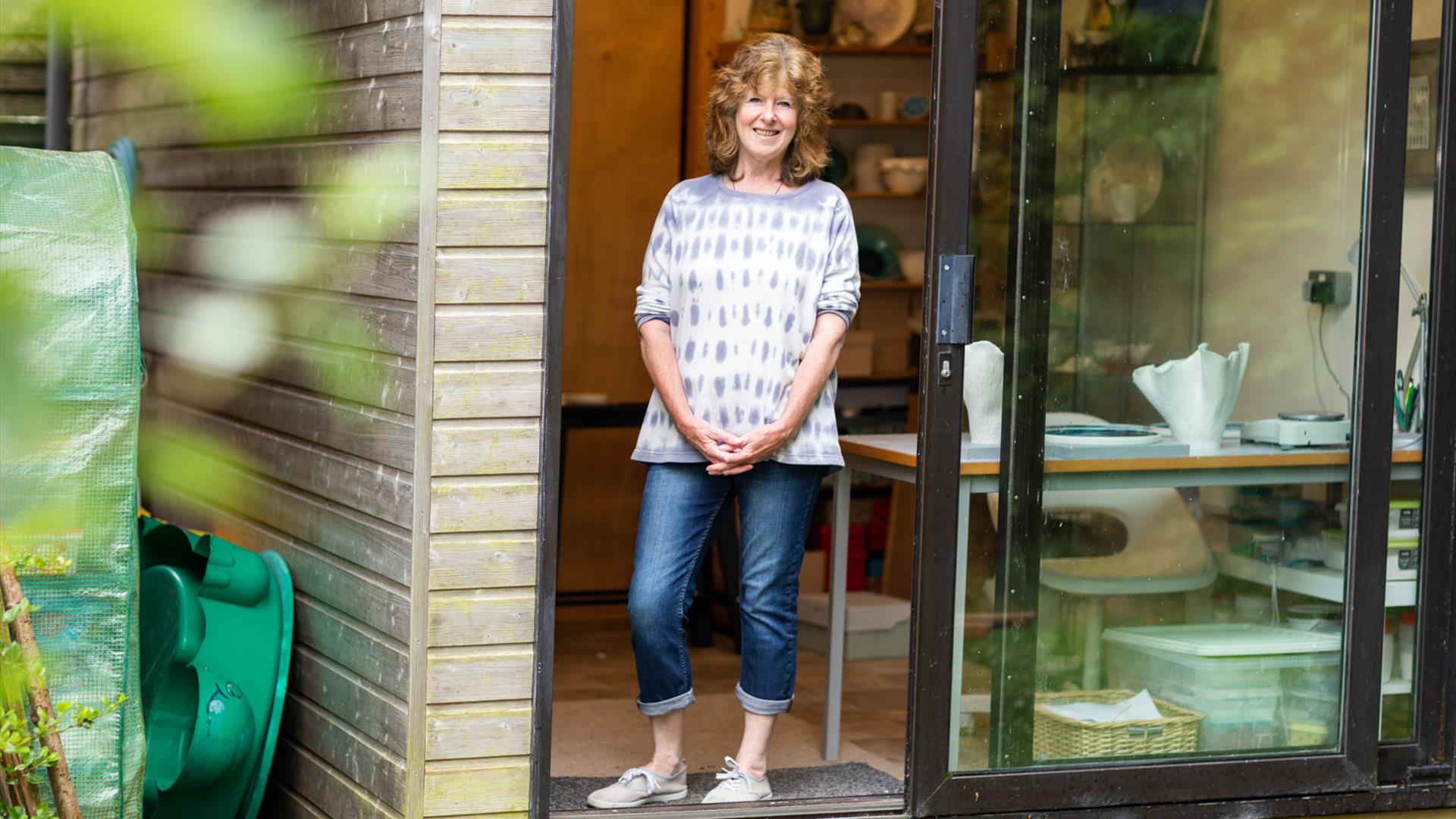 An artist stands at the entrance to their studio