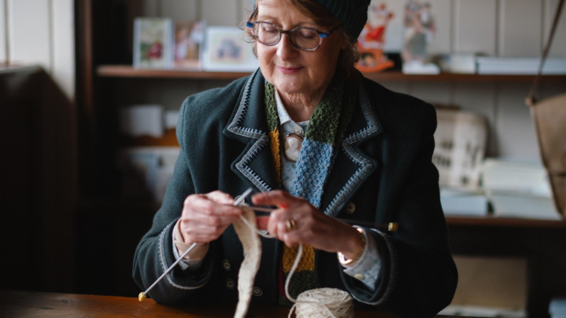 a LADY DRESSED IN HISTORICAL COSTUME KNITTING