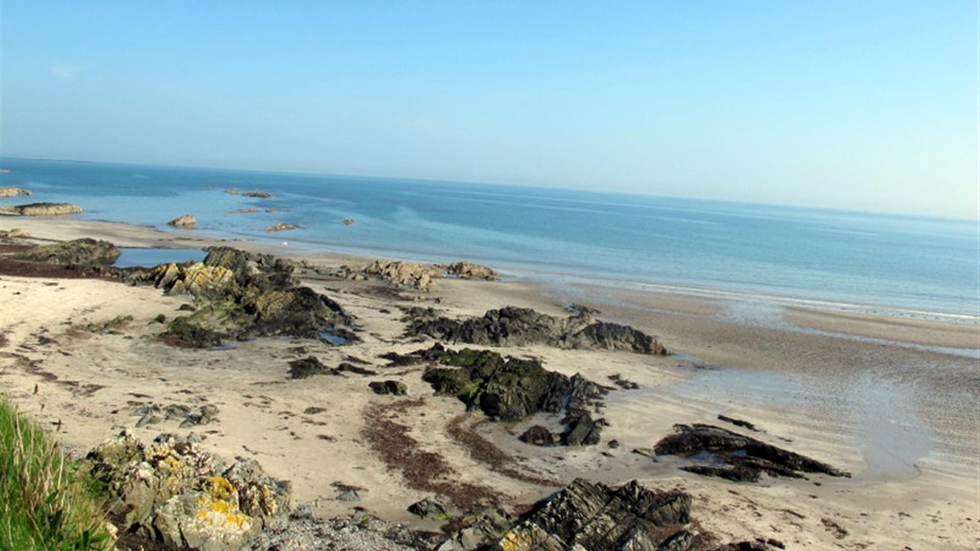photo of the beach showing the sand and the sea