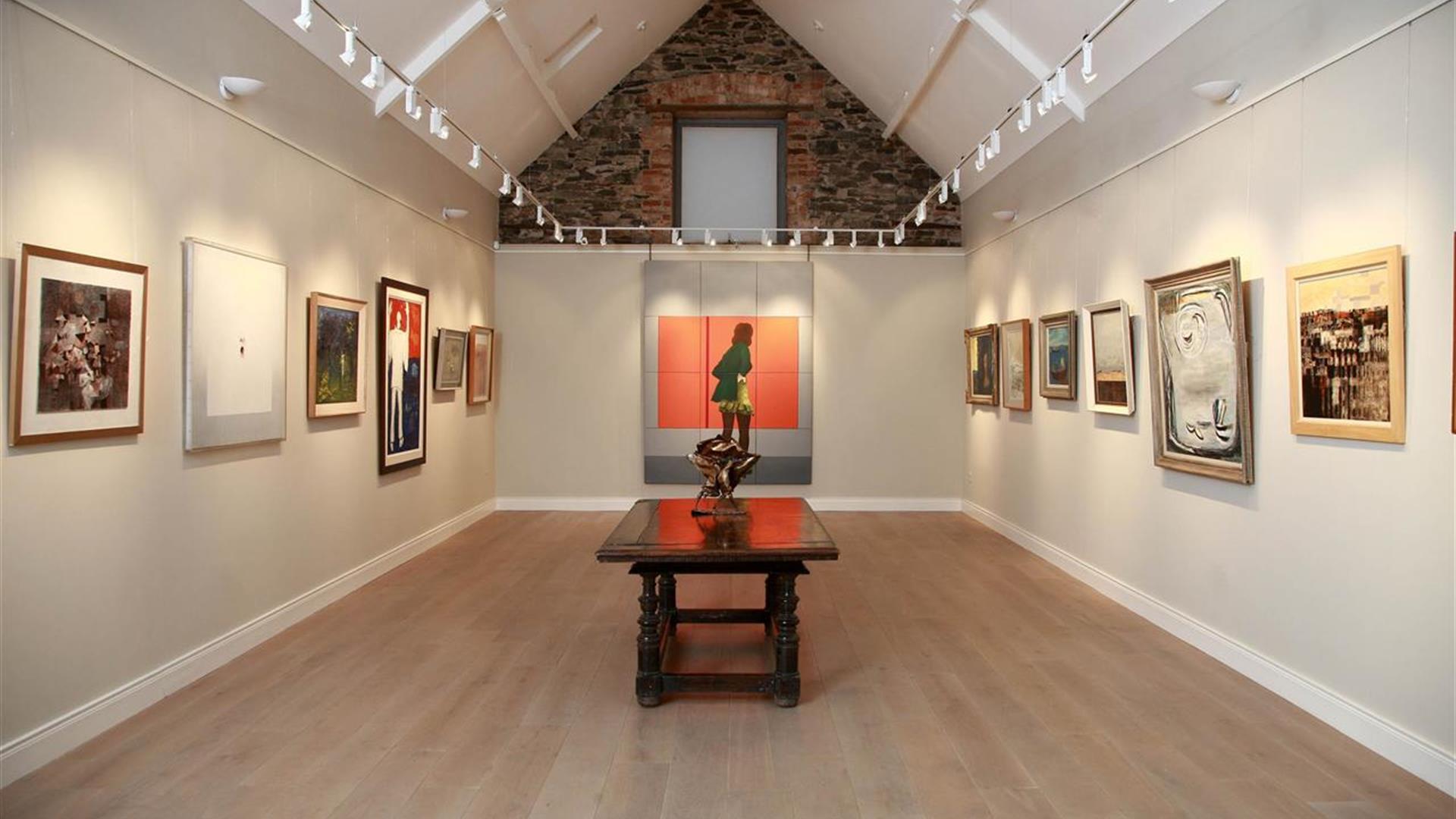 a room in an art gallery with paintings on the wall