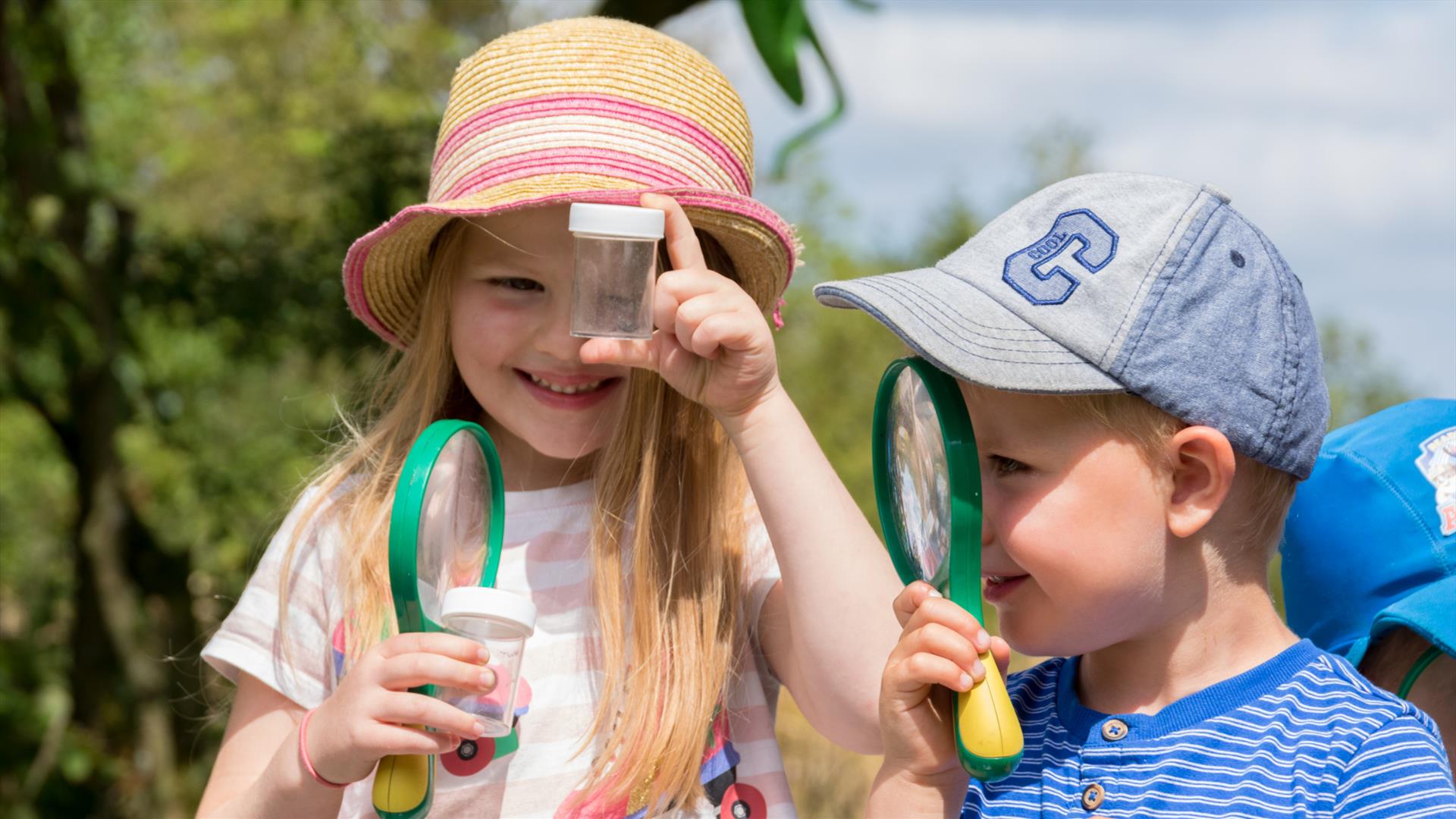 Two children looking through magnifying glasses.
