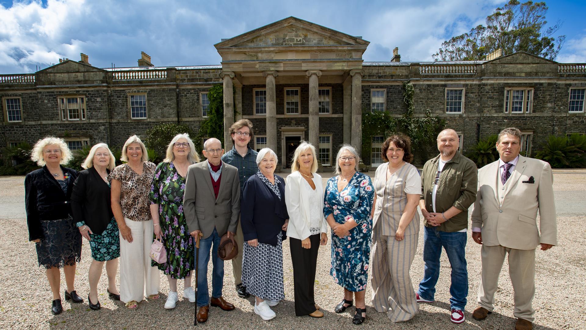 A group of people standing in front of Mount Stewart House