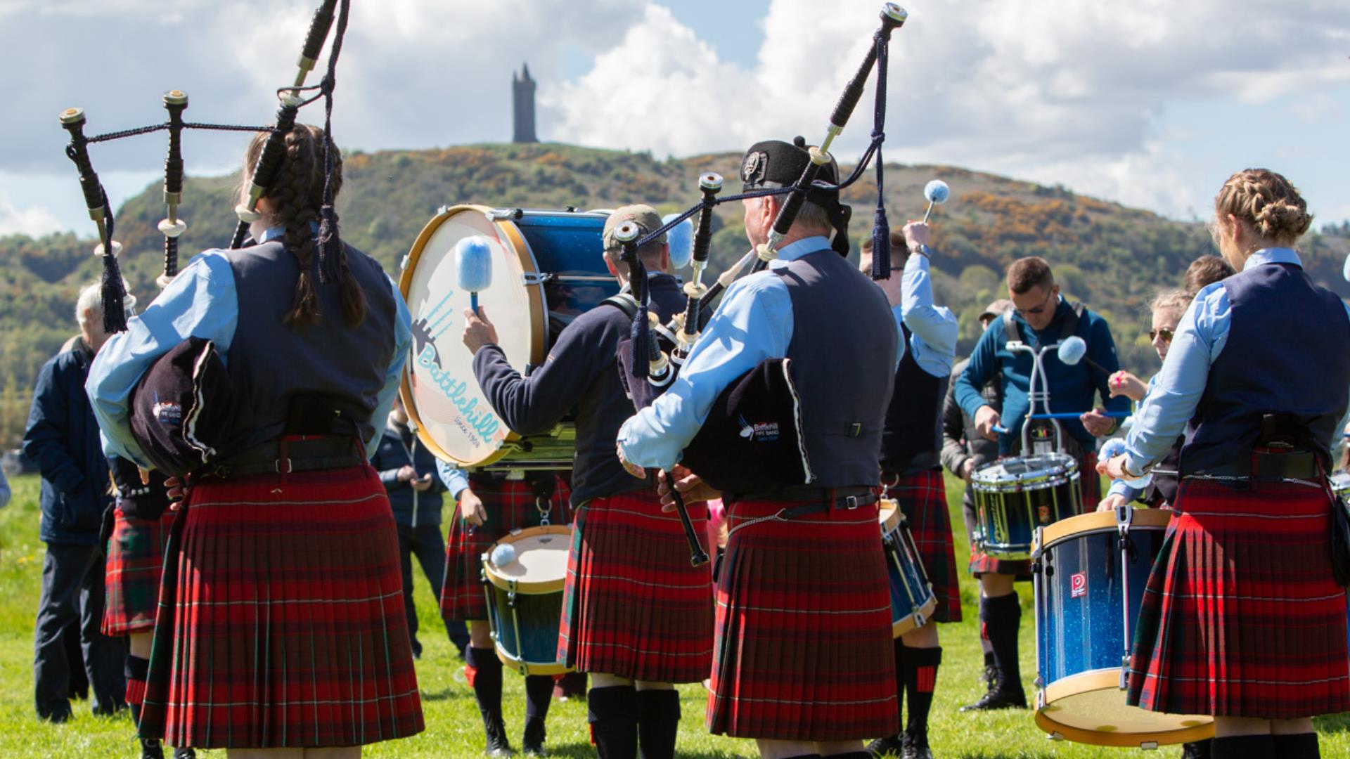 A Pipe Band performs in Ards Airfield with Scrabo Tower in the background