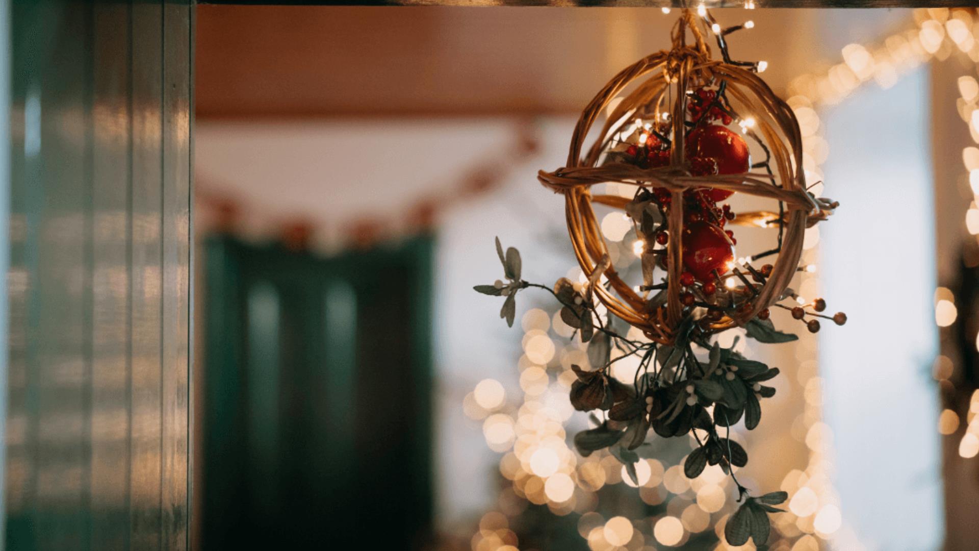 Focus on Christmas hanging decor with twinkling lights in the background