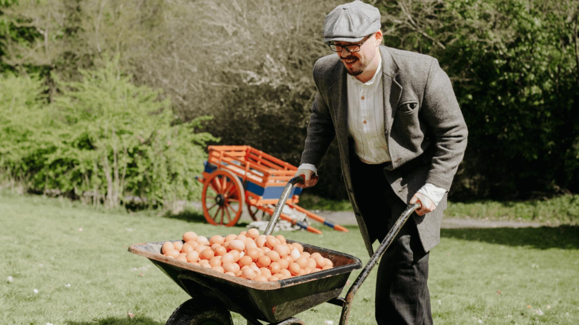 a man pushing a cart of eggs for an easter egg hunt
