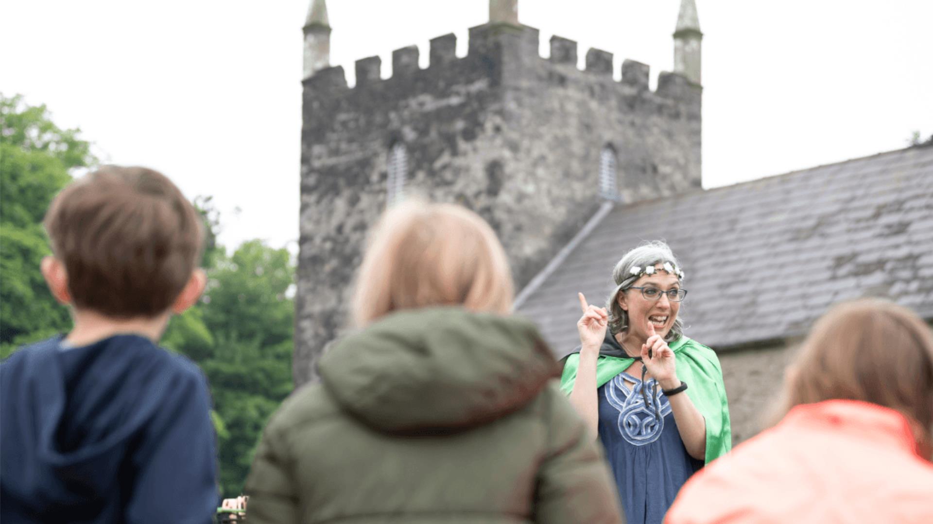 a lady talking to children at the folk museum