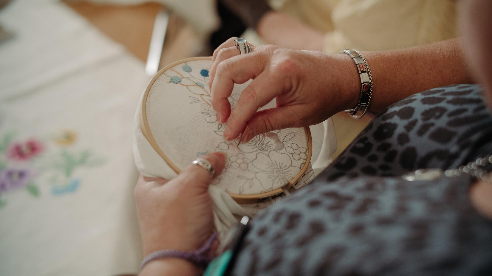 A lady using a hoop to embroider
