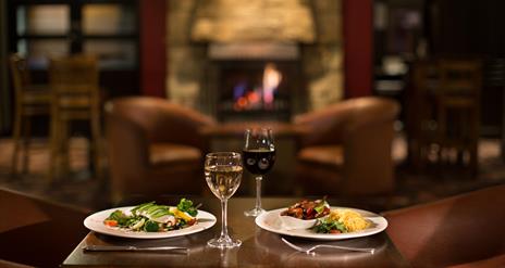 Table set for two with meals and glasses of wine