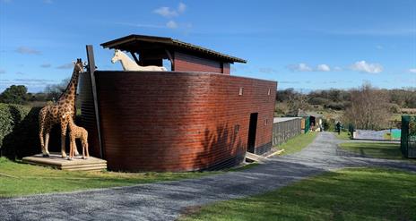 Image of the Ark Open Farm's small replica of Noah's Ark with animal statues including giraffe