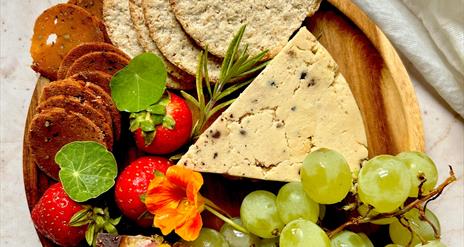 A selection of cheese, crackers, fruit and garnish