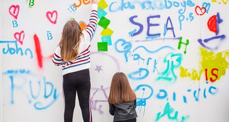 Kids having a go at the Sea Bangor Graffiti wall