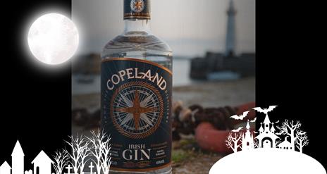 A bottle of Copeland Gin with Donaghadee Lighthouse in the background, with an overlay of spooky themed graphics for Hallowe'en