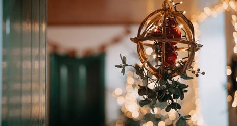 Focus on Christmas hanging decor with twinkling lights in the background