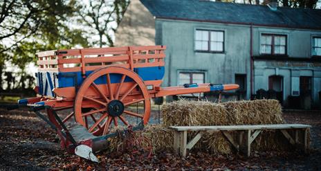 A wagon and hay bales set in Ballycultra Village in Ulster Folk Museum