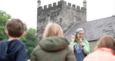 a lady talking to children at the folk museum