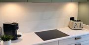 Modern kitchen worktop with hob, coffee machine and toaster.