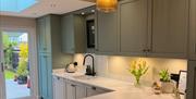 Modern kitchen with breakfast bar and garden access.