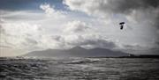 A kite surfer taking off into the air from the water