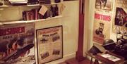 Photo's of an officers office setting featuring signs and posters encouraging men to enlist to the war, as well as featuring gear and accessories of t