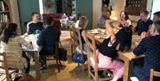 A group around two tables enjoying baked treats and tea