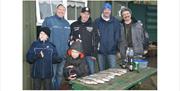 Generations of men and boys together with fish they caught
