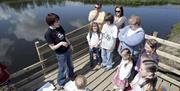 a photograph of a group of people standing next to a lake
