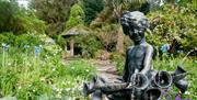 Photo of the bronze statue that commemorates the birth of Lady Mairi in 1921, surrounded by bells and cockle shells based on the nursery rhyme, set wi